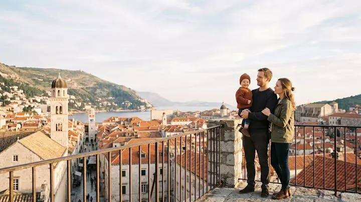 Genitori e bambino osservano il panorama di una destinazione di vacanza europea, simbolo di serenità e pianificazione familiare